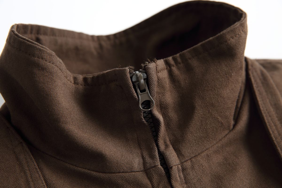 Close-up of the Hagane jacket's stand collar and the zip beneath the wrap-over front panel